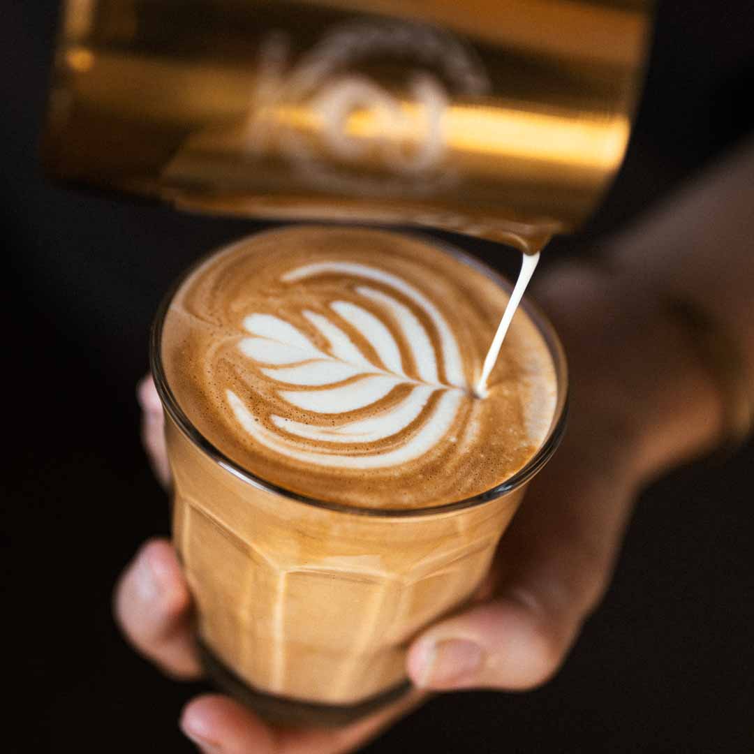 Giessen von Latte-Art Herzen bei einem Cappuccino mit Specialty Coffee Bohnen